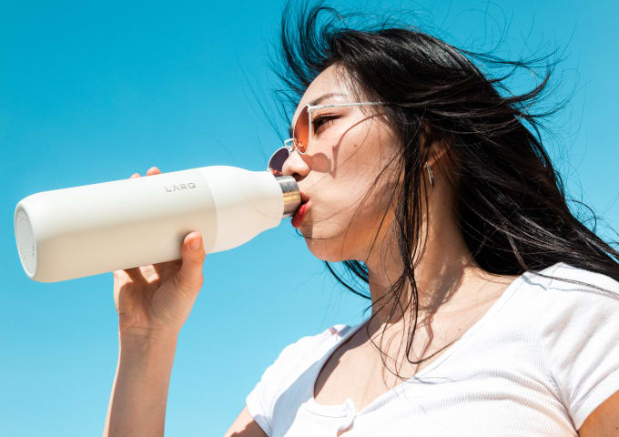 Woman drinking water from Larq bottle twist top granite white